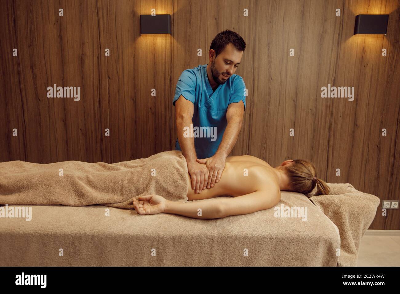 Male masseur rubbing back to slim woman with his elbow, professional massage.  Massaging and relaxation, body and skin care. Attractive lady in a spa s  Stock Photo - Alamy