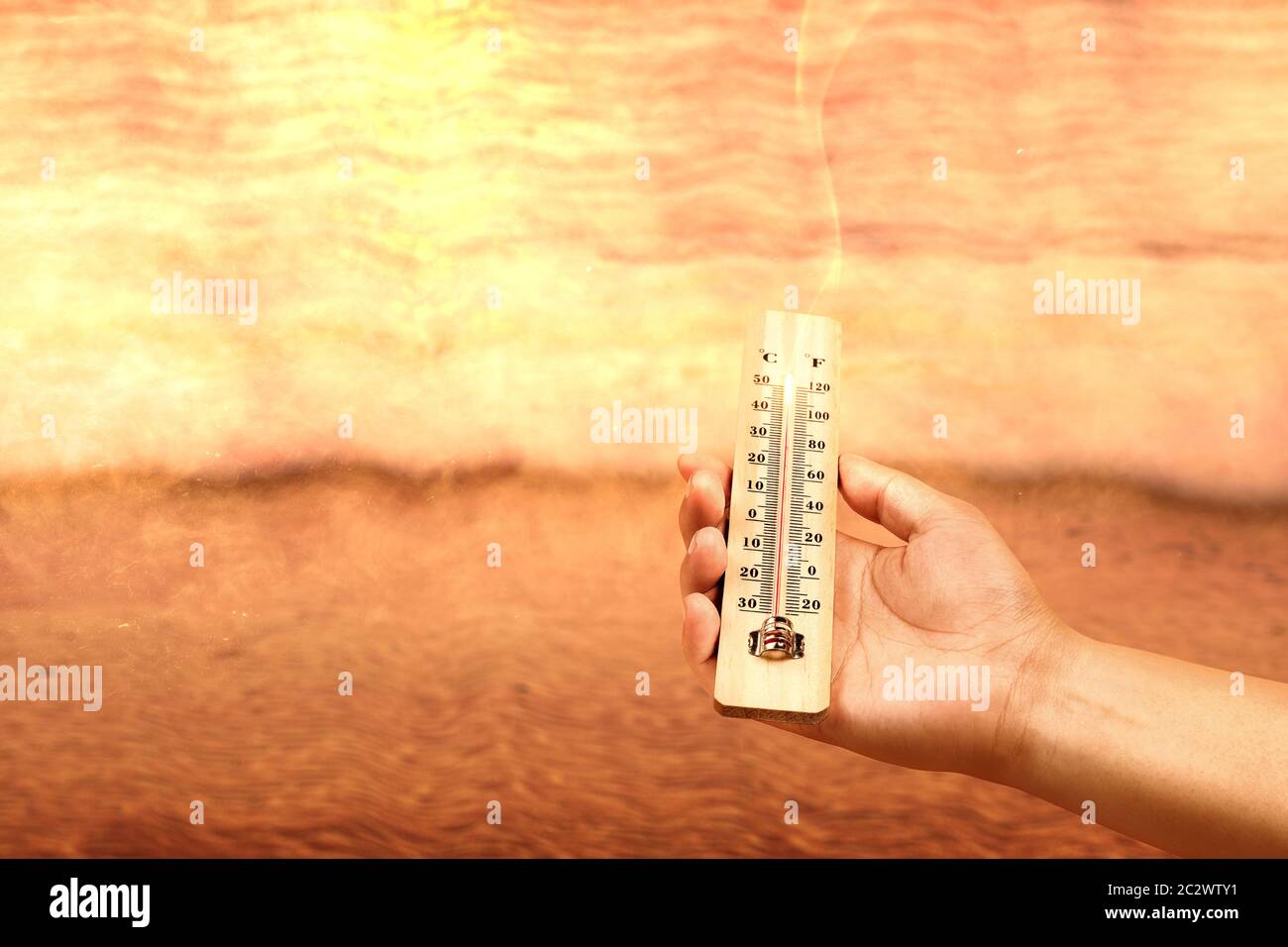 https://c8.alamy.com/comp/2C2WTY1/hand-holding-thermometer-with-high-temperature-on-the-beach-with-glowing-sun-background-heatwave-concept-2C2WTY1.jpg