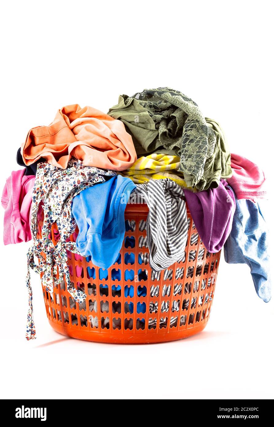 Red plastic laundry basket full of colorful clothes Stock Photo