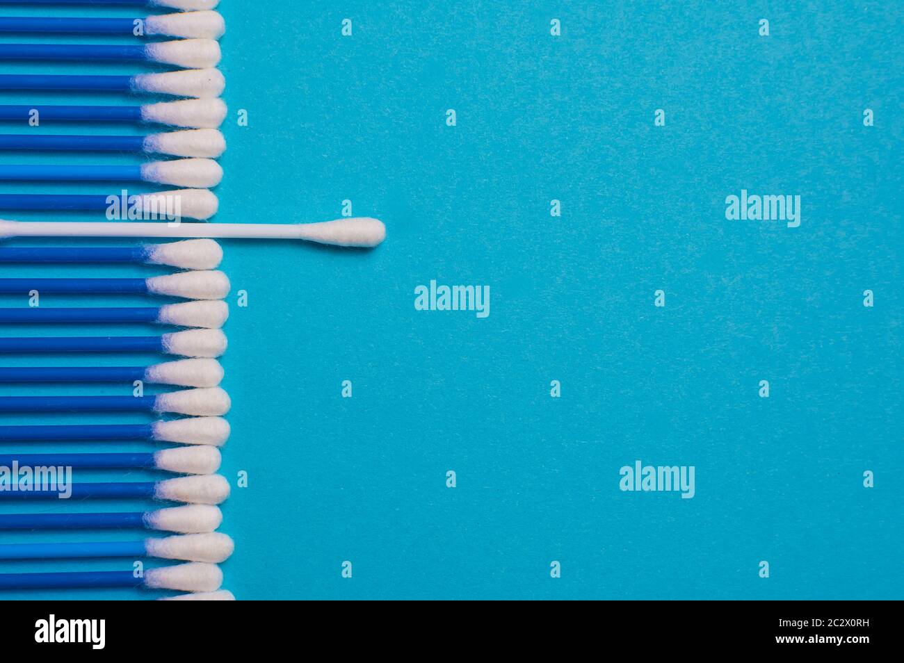 Ear sticks on a blue background. Medical sticks for smear. Sticks for cleaning ears lie in a row, on a blue background. Place for the text. opy space Stock Photo