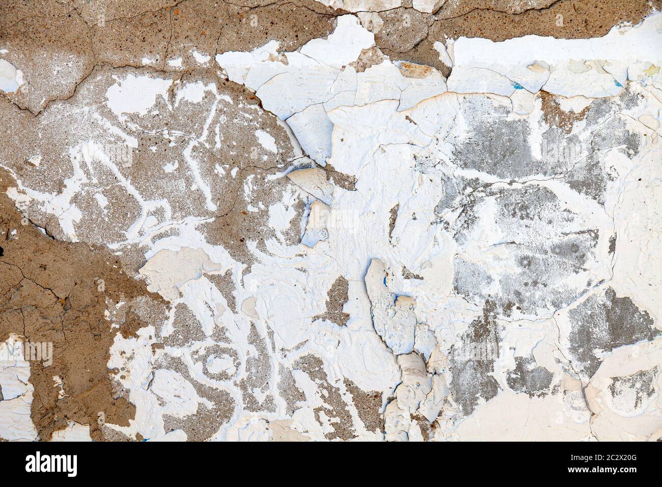 Cracked and crumbling plaster from a white wall - a wallpaper
