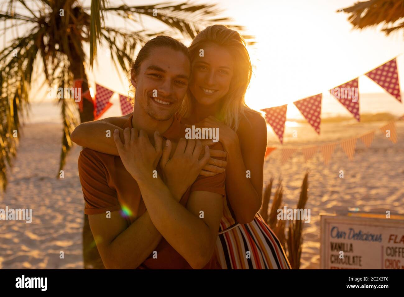 Caucasian friends hugging on beach Stock Photo