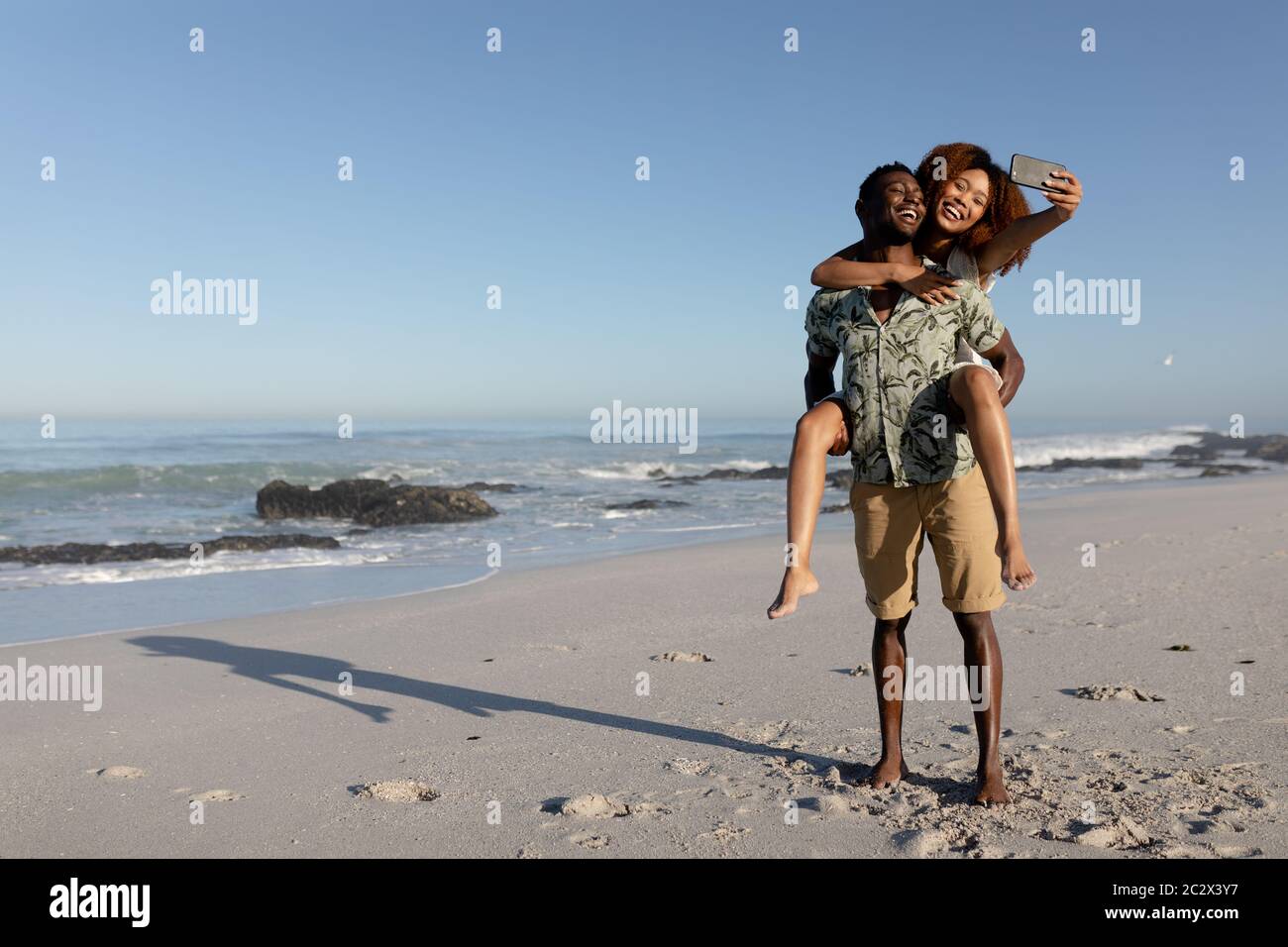 Happy couple taking a selfie on the beach Stock Photo