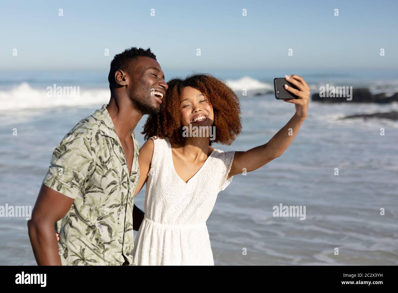 Happy couple taking a selfie on the beach Stock Photo