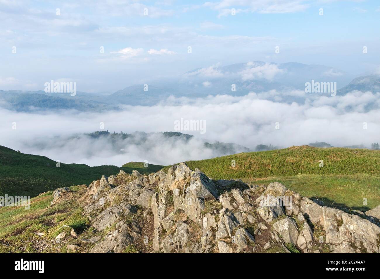 The Summit of Loughrigg Fell and the View West over Cloud Filled Valleys, Lake District, Cumbria, UK Stock Photo