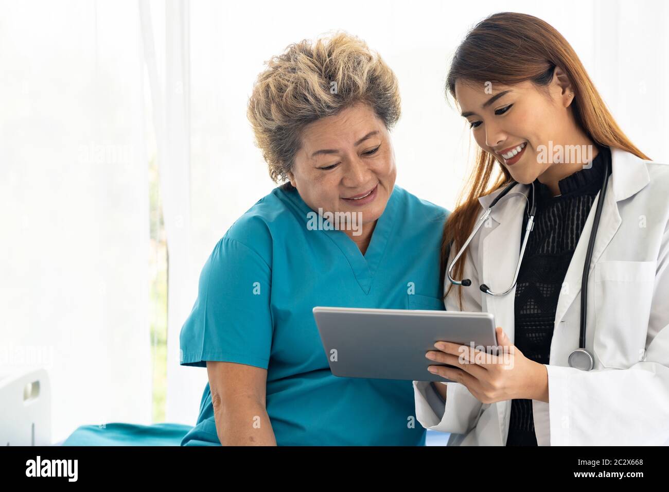 Doctor using tablet with old patient Stock Photo