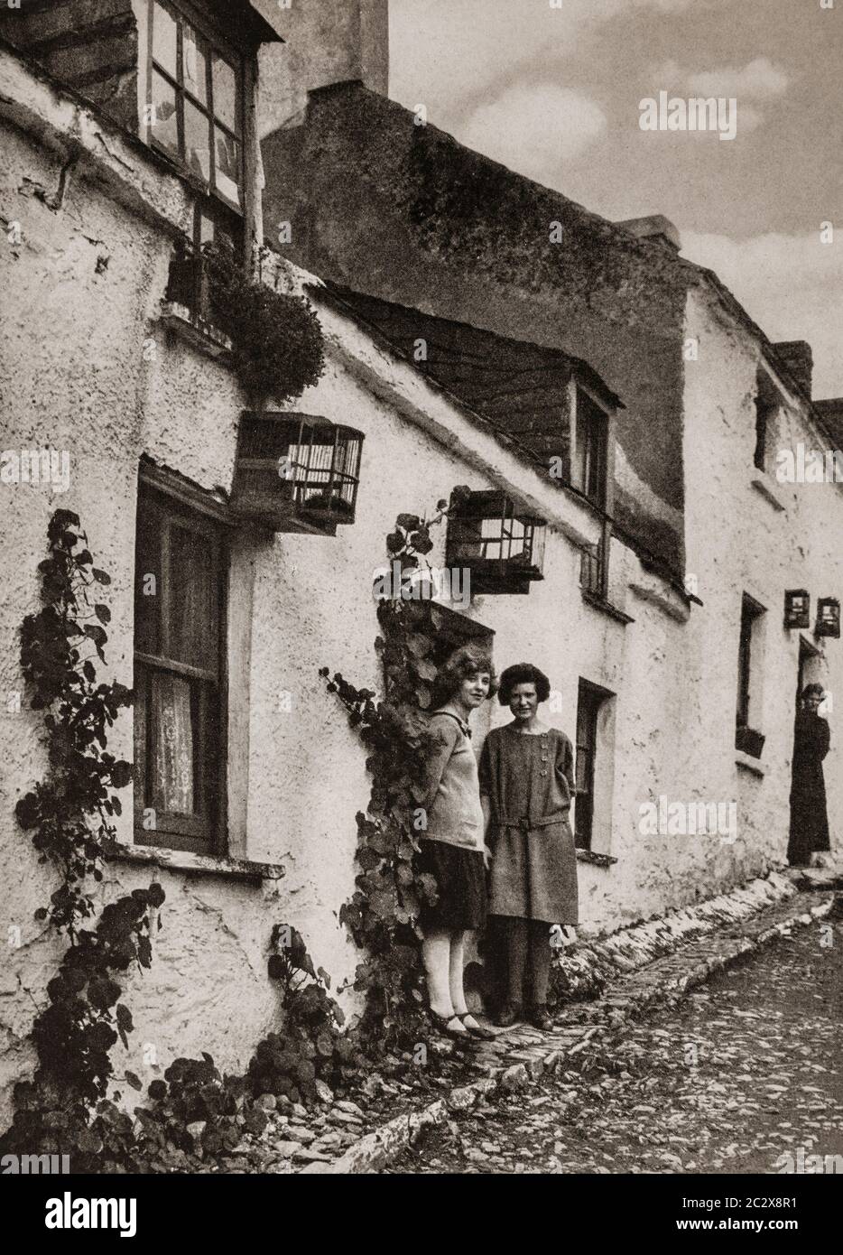 In early 1920's, birdcages were often hung outside houses in Cobh in County Cork, Ireland. Originally photographed by Clifton Adams (1890-1934) for 'Ireland: The Rock Whence I Was Hewn', a National Geographic Magazine feature from March 1927. Stock Photo