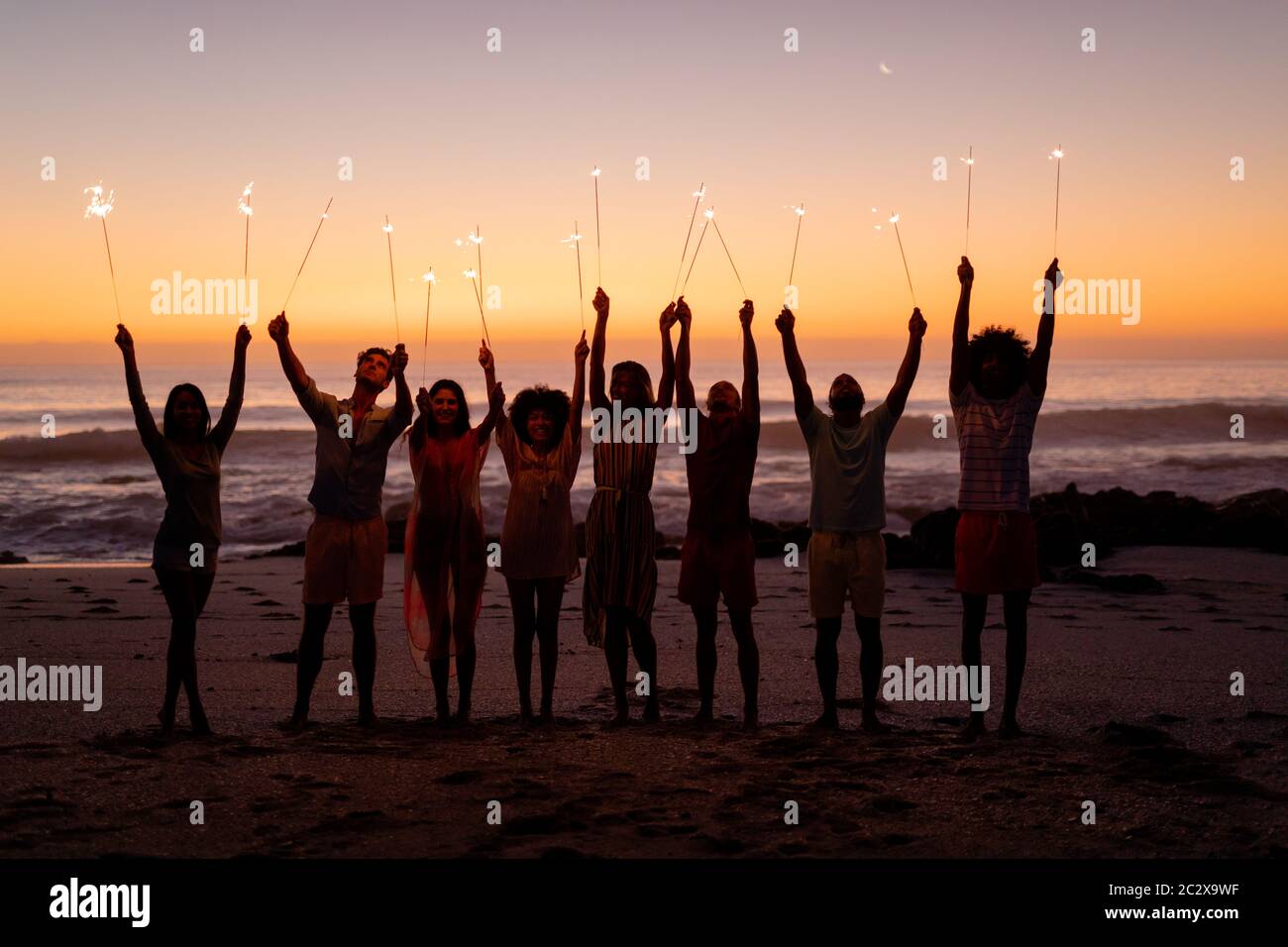 Multi-ethnic group of male and female having fun on the beach Stock Photo