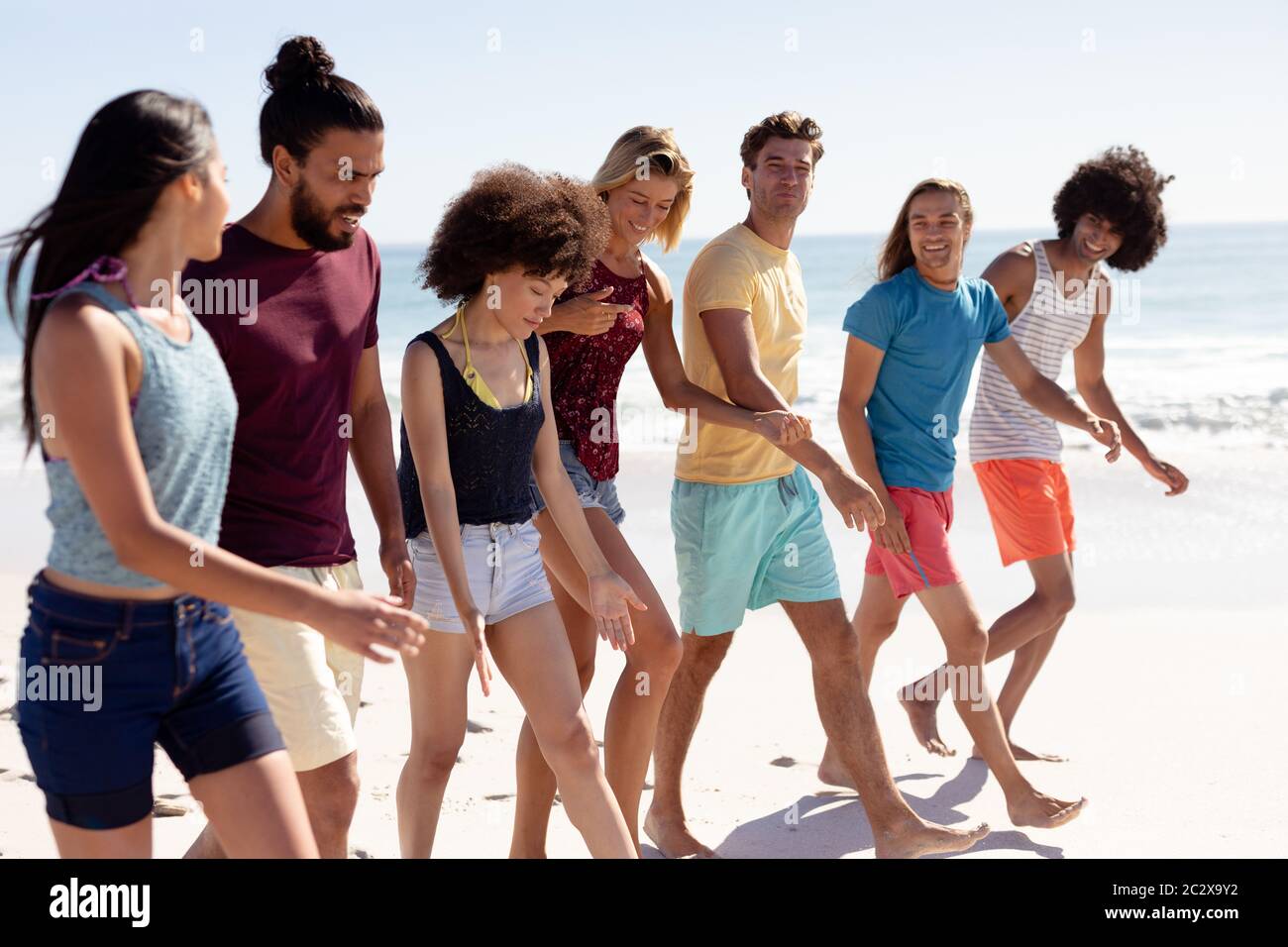 Multi-ethnic group of male and female standing on the beach Stock Photo