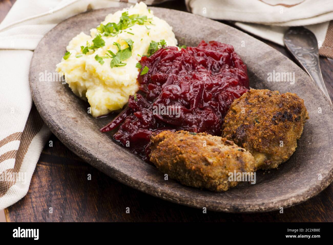 Prepared dinner on the plate. Melted meat, potatoes, beetroot Stock Photo