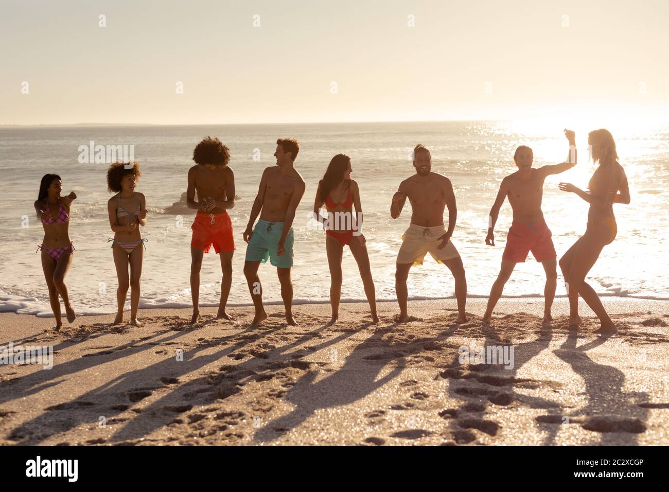 Multi-ethnic group of male and female dancing on the beach Stock Photo