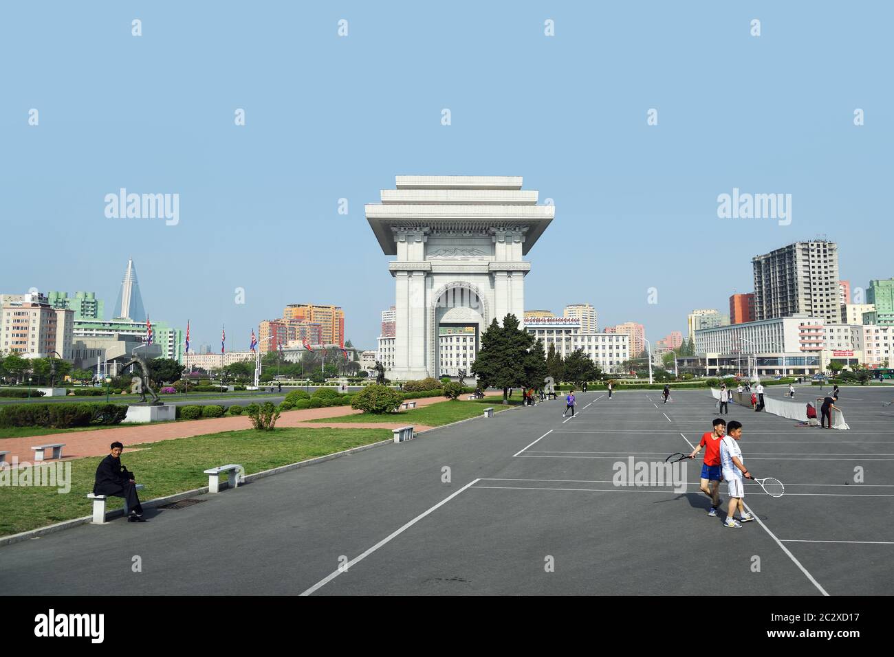 Pyongyang, North Korea - May 1, 2019: People play tennis next to Arch of Triumph. A monument built in Pyongyang in honor of the Korean resistance of 1 Stock Photo