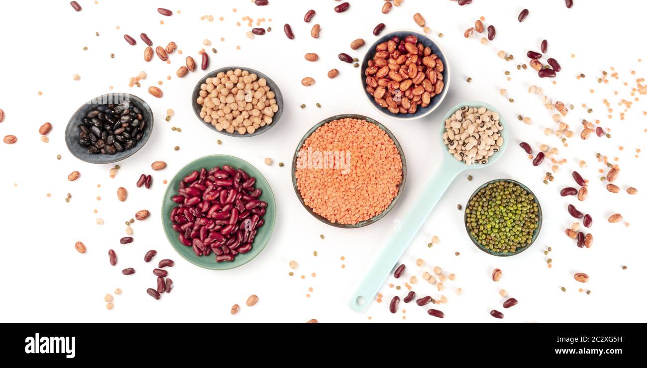 Legumes panorama, an overhead shot on a white background. Various pulses. Kidney beans, lentils, soybeans, chickpeas, a flat lay Stock Photo