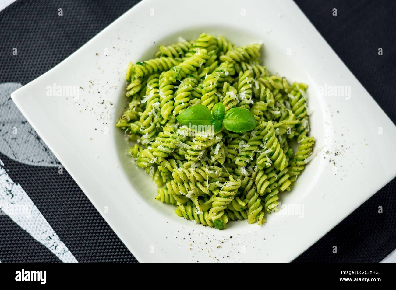 Rotini pesto pasta top view. Rotini pasta with basil pesto sauce, grated parmesan cheese and