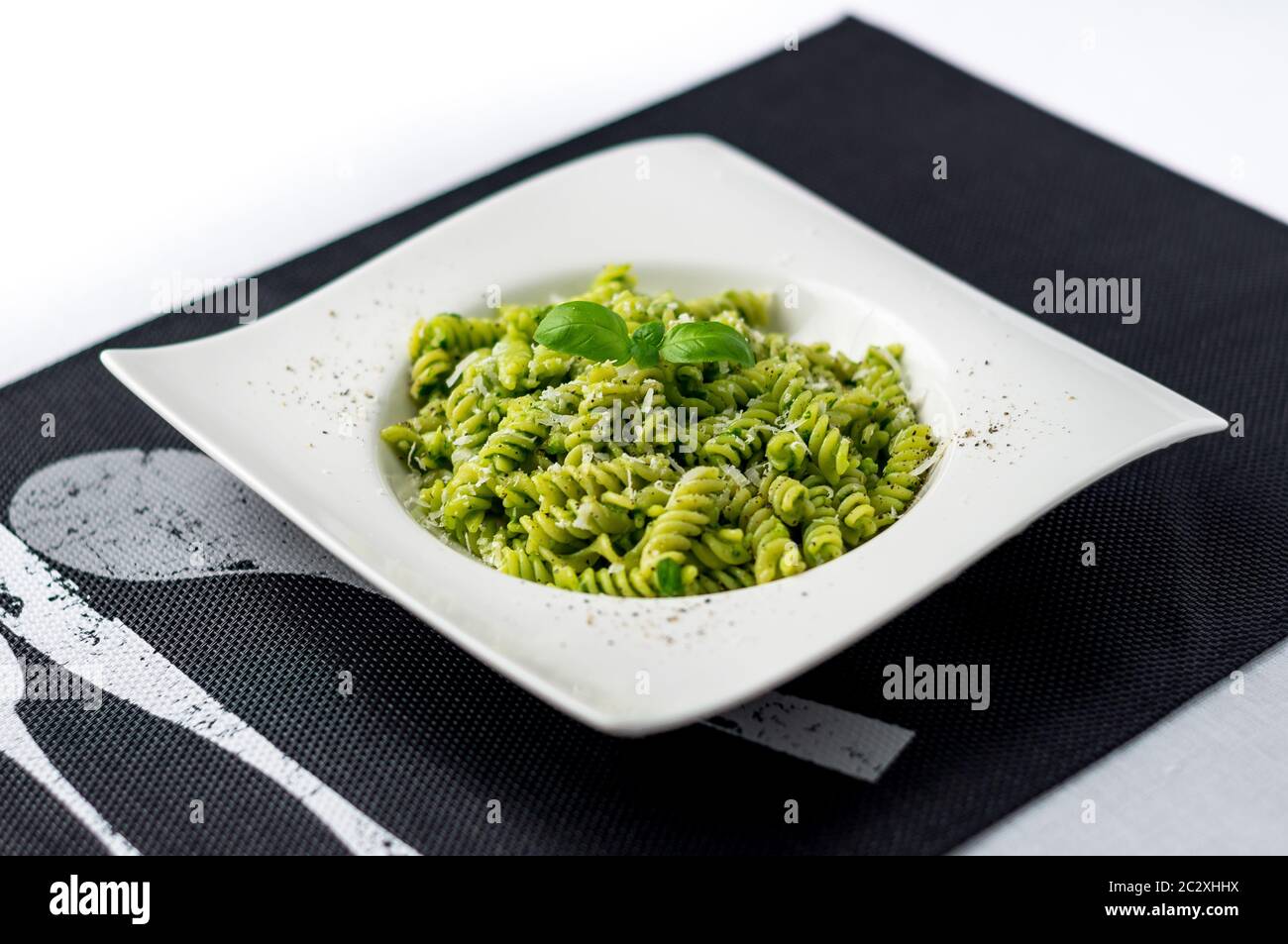 Basil pesto pasta salad. Rotini pasta with basil pesto sauce, grated parmesan cheese and fresh pepper. This Italian dish makes a delicious meal. Stock Photo