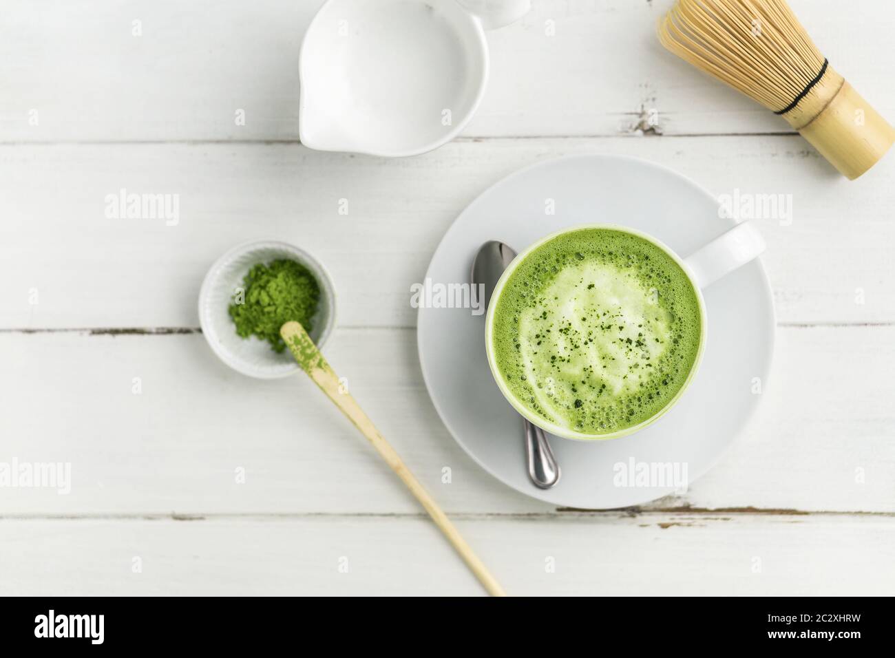 Matcha latte cup on white background from above. This latte is a delicious way to enjoy the energy boost & healthy benefits of matcha. Stock Photo