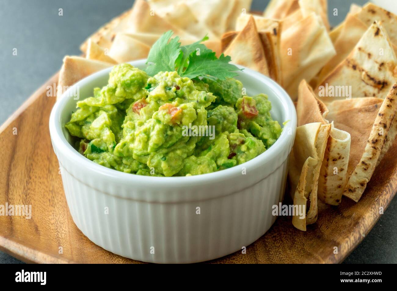 Fresh guacamole bowl. Guacamole is a avocado based dip, traditionally a mexican (Aztecs) dish. Healthy and easy to make snack at home. Stock Photo