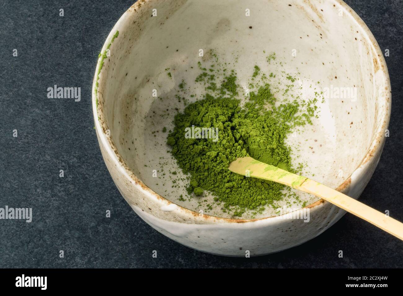 Matcha powder in bowl with Chashaku matcha spoon. Matcha is made of finely ground green tea powder. It's very common in japanese culture. Matcha is he Stock Photo
