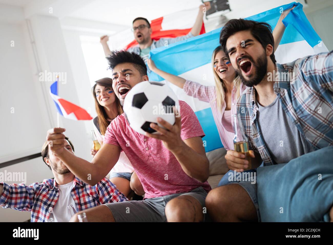 People, leisure, rivalry and sport concept. Happy and sad friends or fans watching match at home Stock Photo