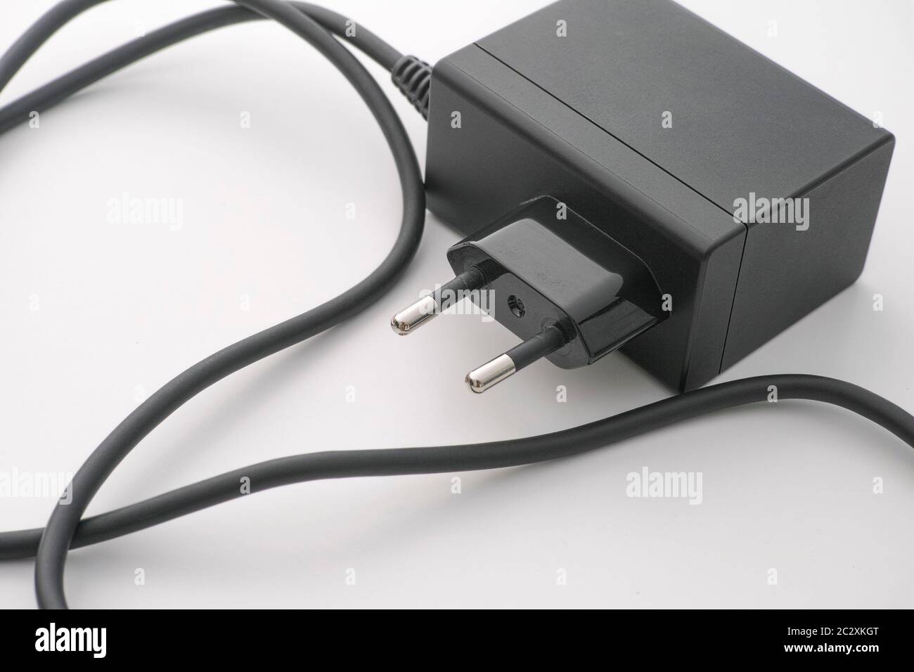 An AC adapter with some dust on it laying on a table. Close up. Stock Photo