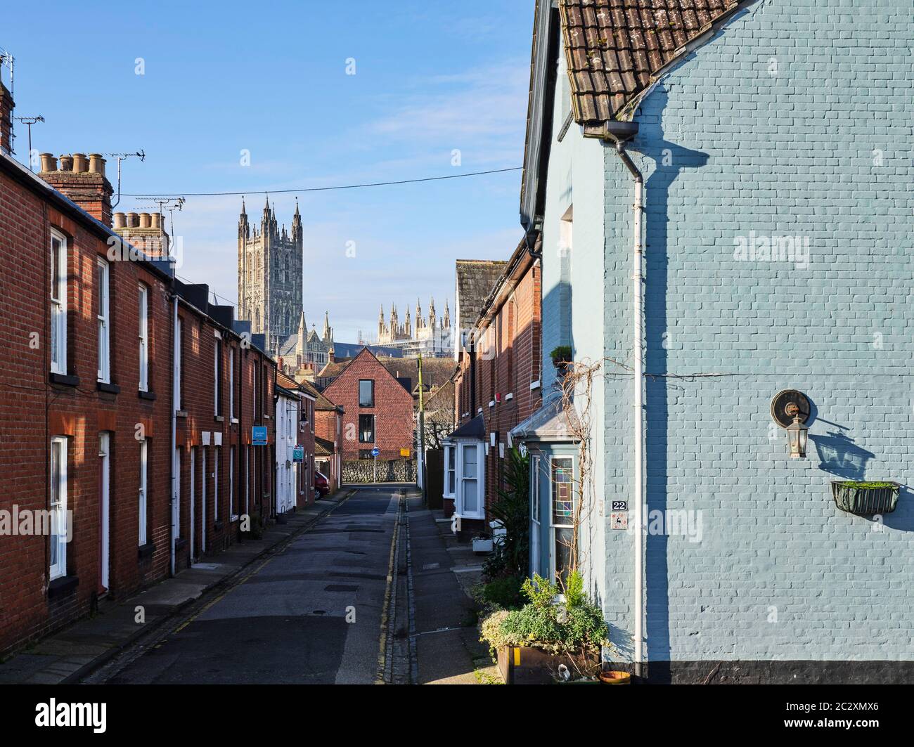View down street with blue painted house, the building and Cathedral. Kingsdown House, King's Canterbury, Canterbury, United Kingdom. Architect: Walte Stock Photo
