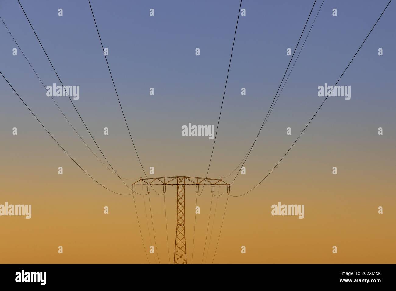 High voltage pylon overhead line at sunset Stock Photo