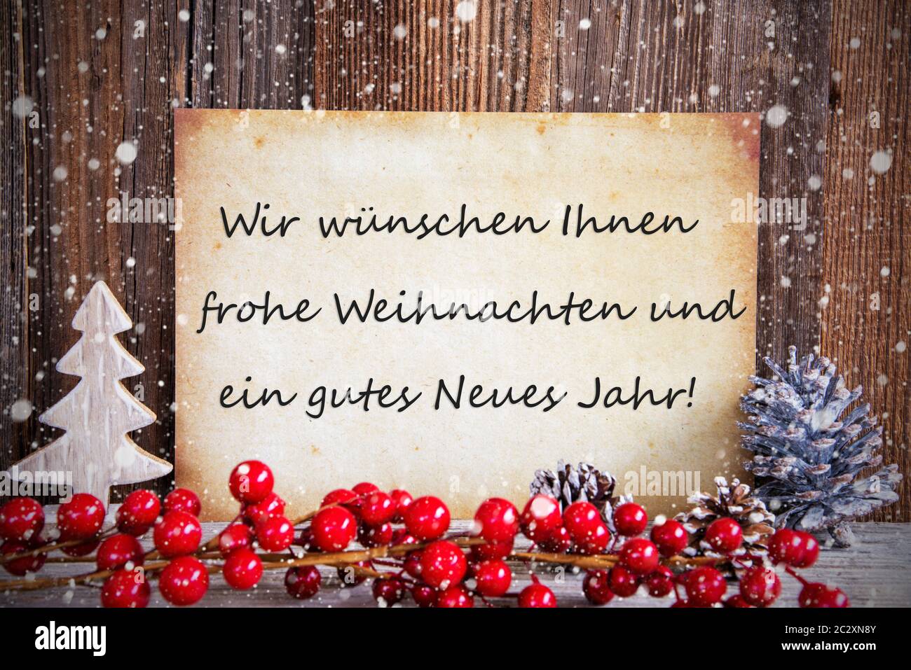 Paper With German Text Frohe Weihnachten Means Und Ein Gutes Neues Jahr Merry Christmas And A Happy New Year. Christmas Decoration And Wooden Backgrou Stock Photo