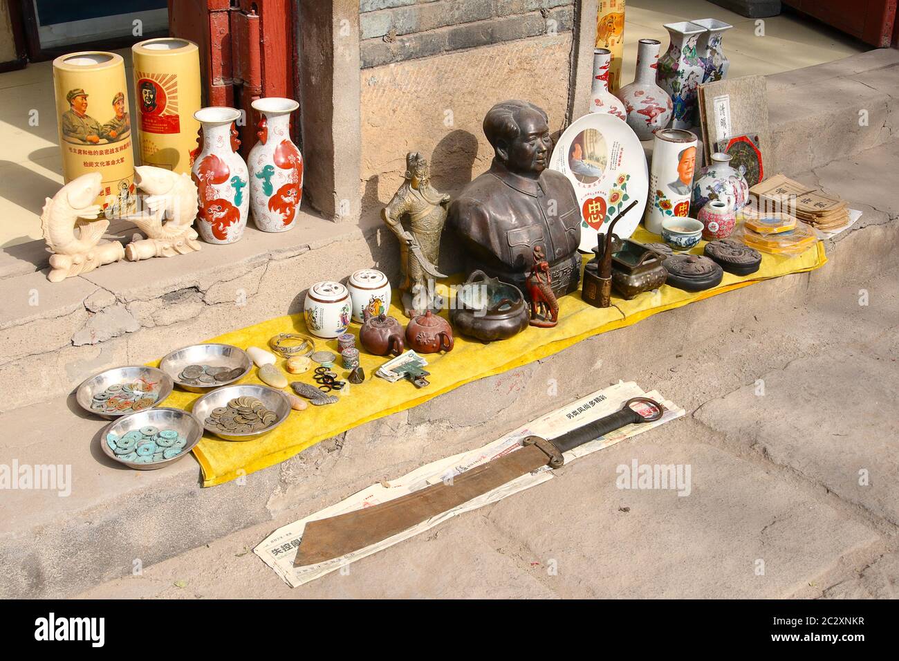 Image showing some antique objects offered for sale on the pavement in front of a shop in the ancient town Zhou Cun, Shandong Province, China. Horizon Stock Photo