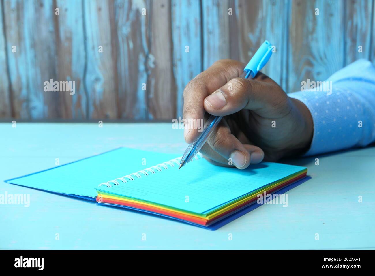 man's hand writing with pen on notepad  Stock Photo