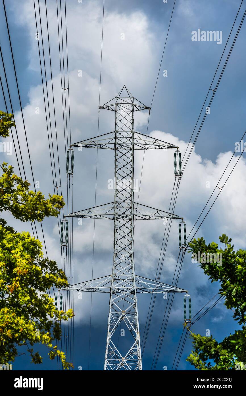 Tall electricity pylon with overhead high-tension power lines. Stock Photo