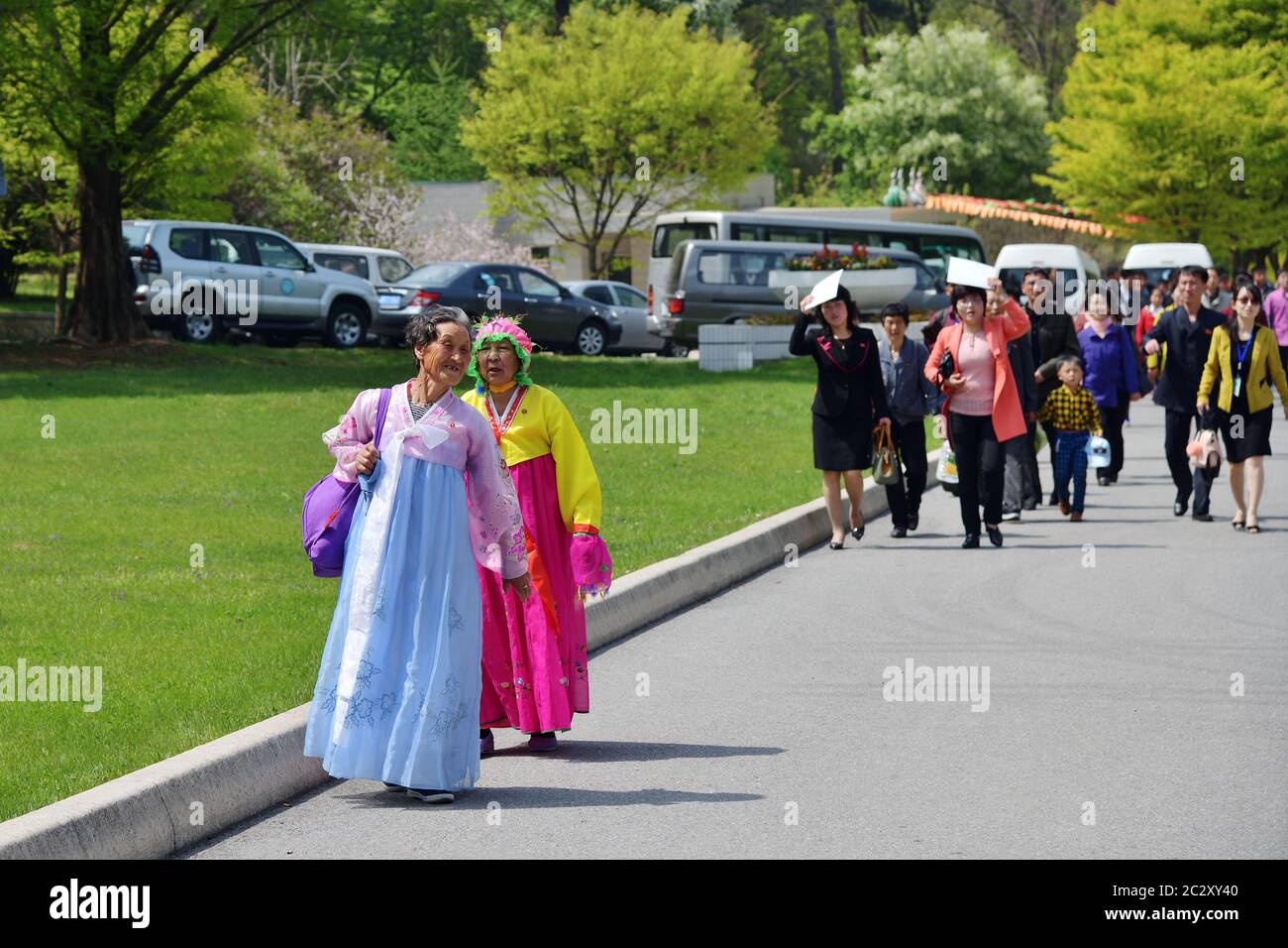 Pyongyang, North Korea - May 1, 2019: Two old women in traditional korean Hanbok dress and another locals walking in the Taesongsan Funfair. Is an amu Stock Photo