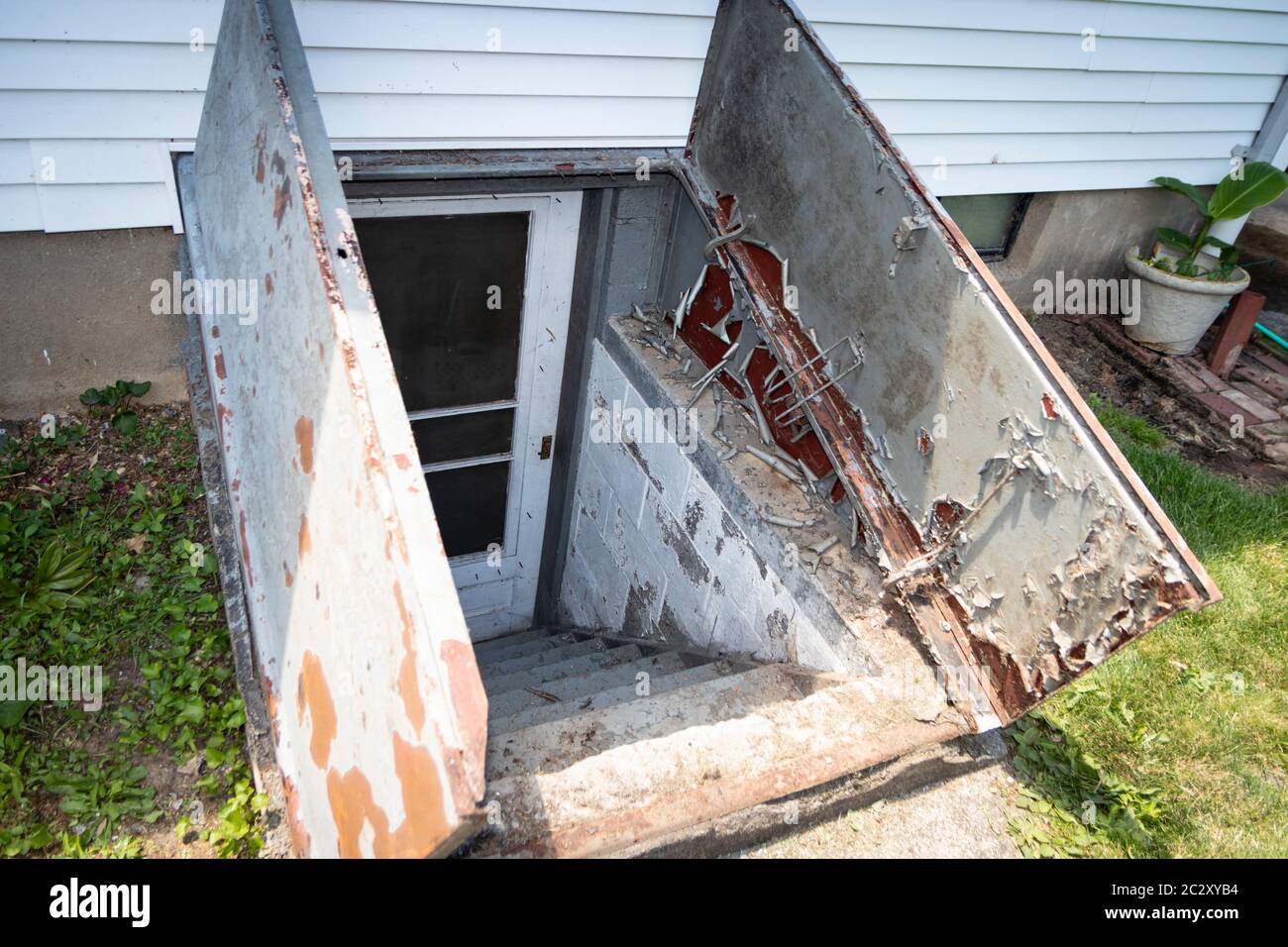 View of cellar doors known as 'Bilco Doors', with paint damage and rust from years of weather, sun, and rain Stock Photo