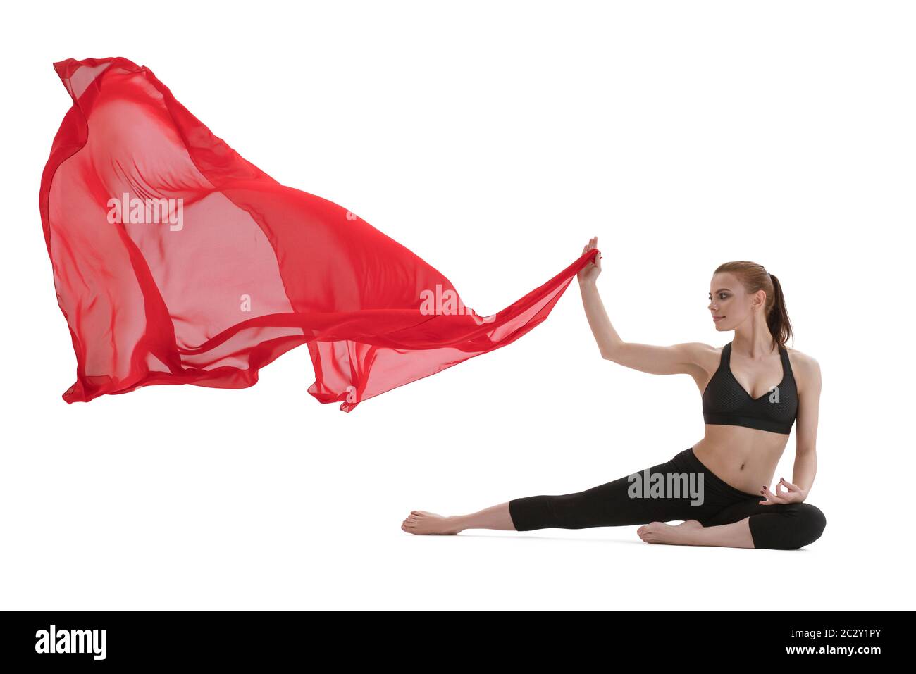 Pretty girl doing yoga posing with red cloth Stock Photo