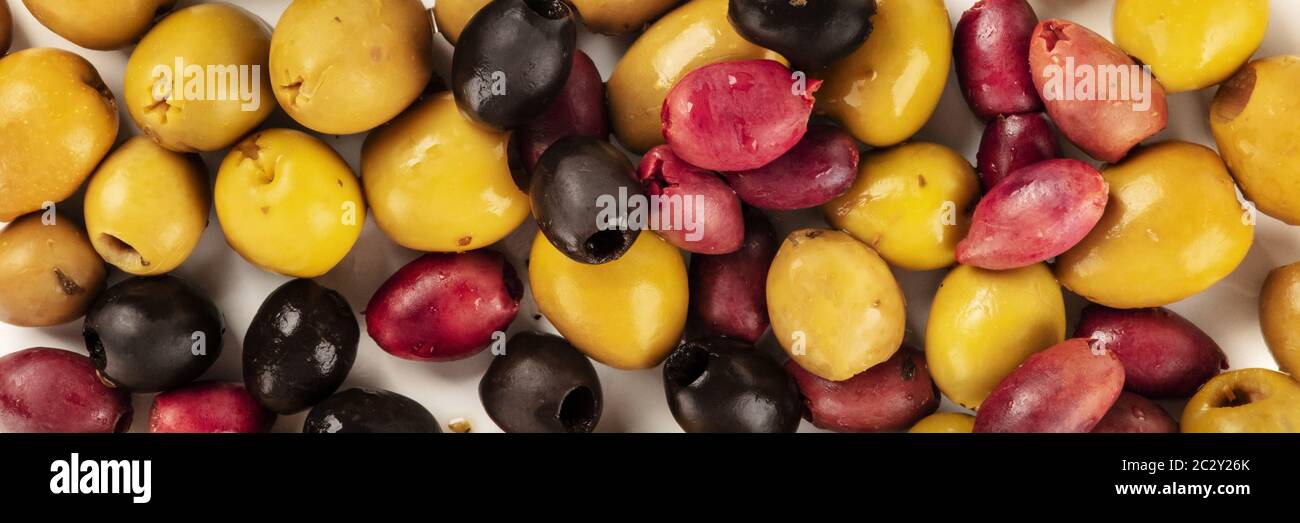 Olives variety panoramic background texture. Black, green and brown olives, an assortment, shot from the top Stock Photo