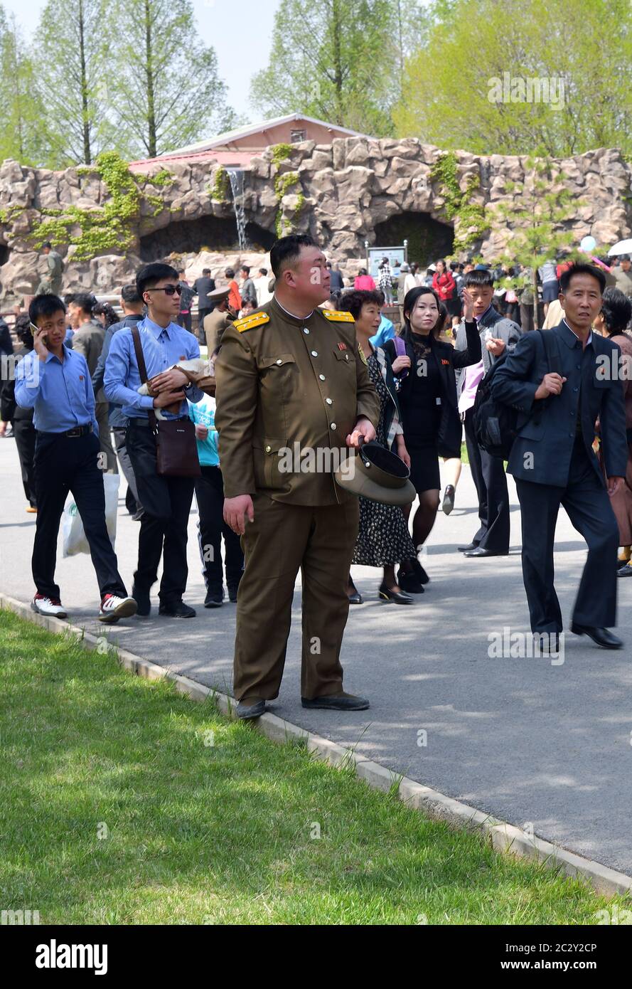Pyongyang, North Korea - May 1, 2019: People gather to celebrate May 1st Labor Day on the Pyongyang street. In the foreground is an officer of the Kor Stock Photo