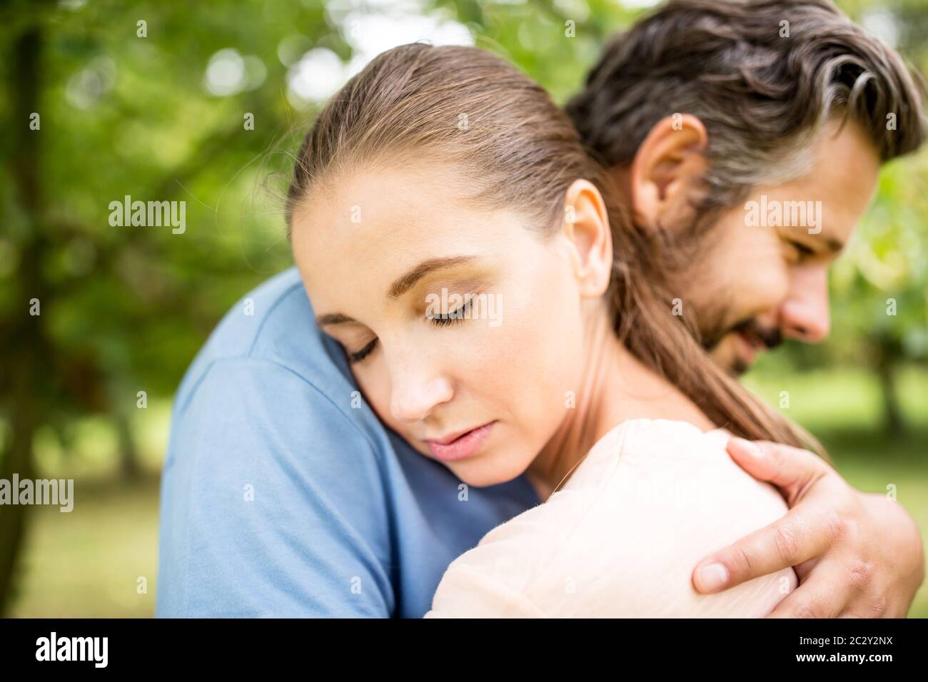 Happy couple in love having a hug in nature Stock Photo - Alamy