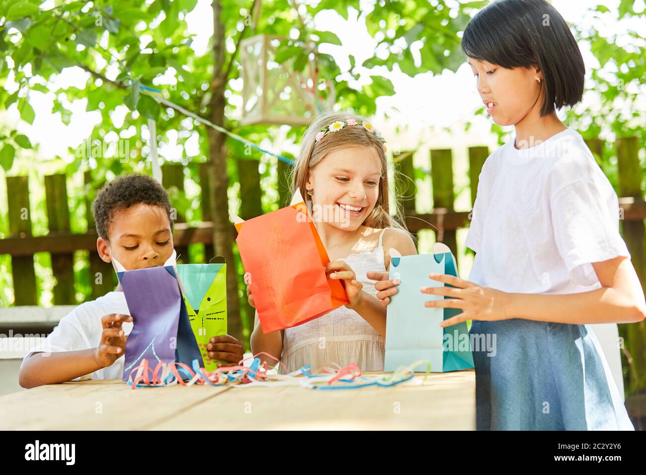 Happy children receive giveaways in gift bags at a birthday party in