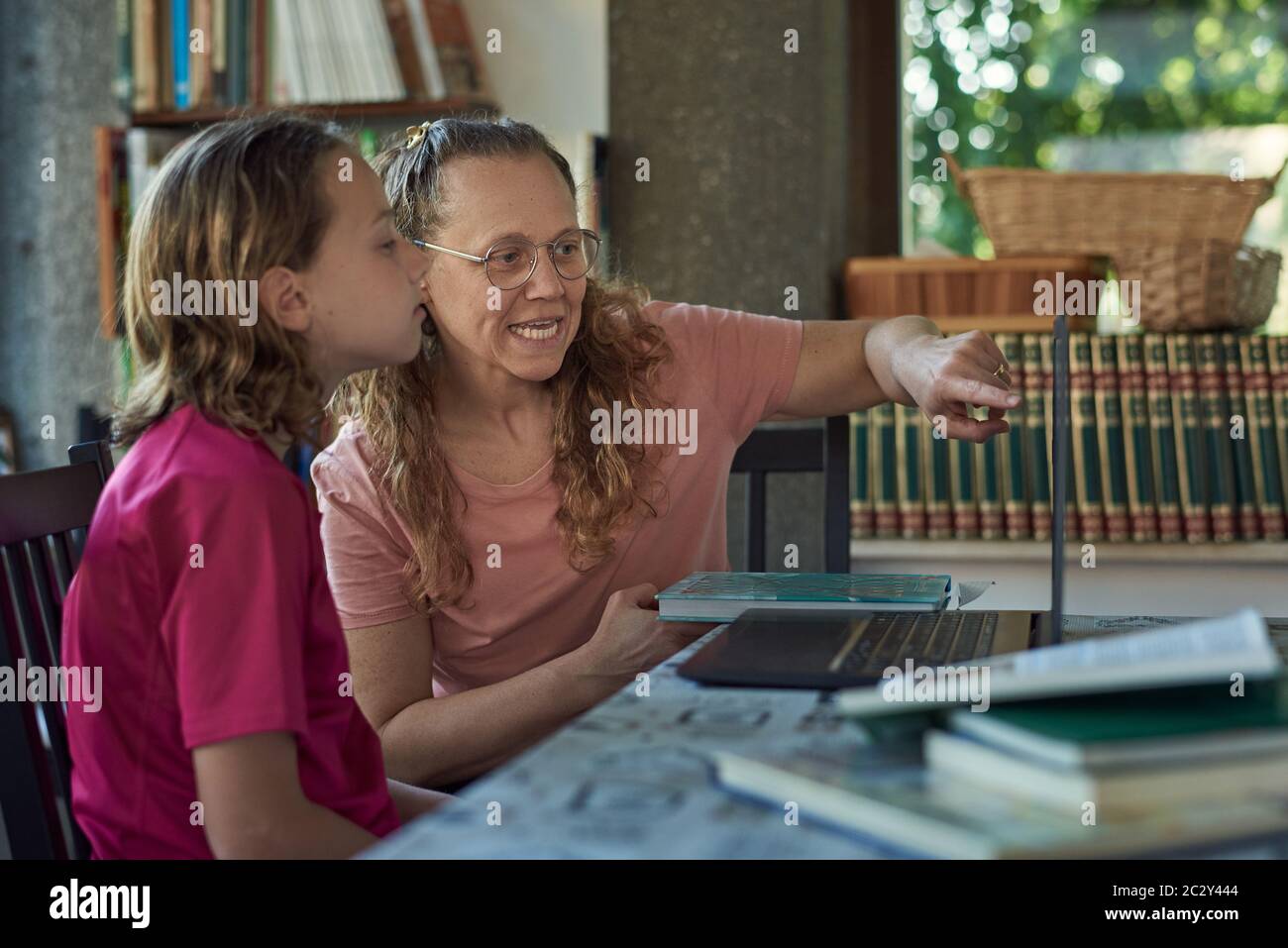 Mother and daughter infront of the laptop studying online Stock Photo