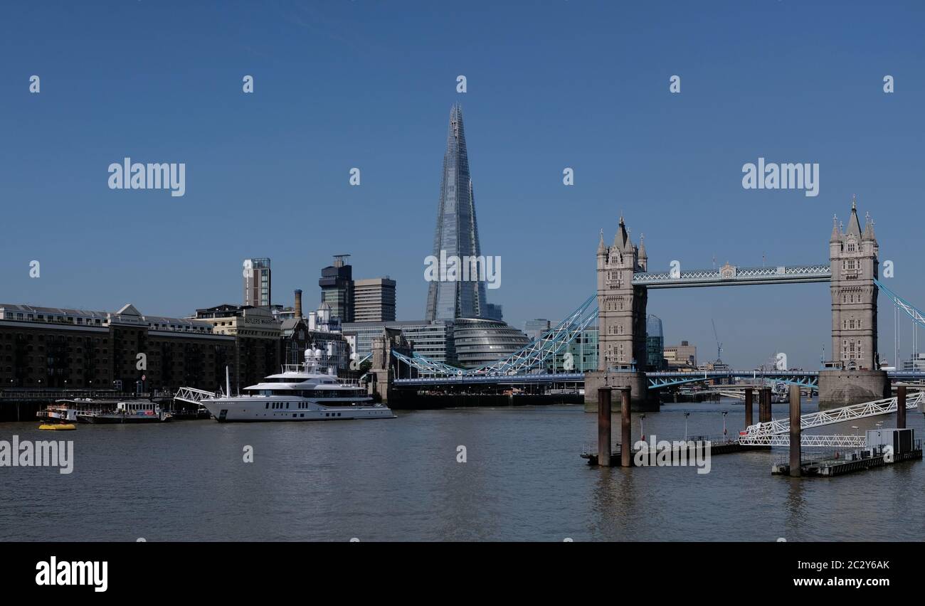 London city skyline showing river Thames Tower bridge Shard and luxury yacht on a sunny day with clear blue sky Stock Photo