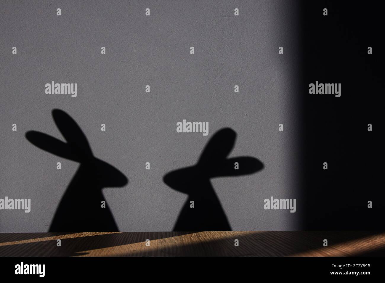 Two Easter bunnies with a shadows at the wall Stock Photo - Alamy