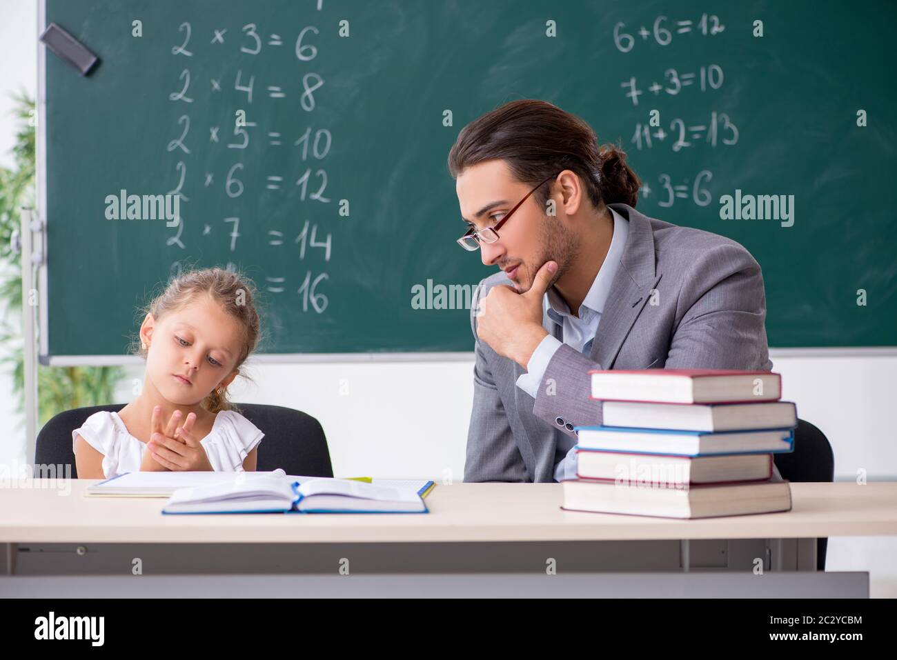 Teacher with young girl in the classroom Stock Photo - Alamy