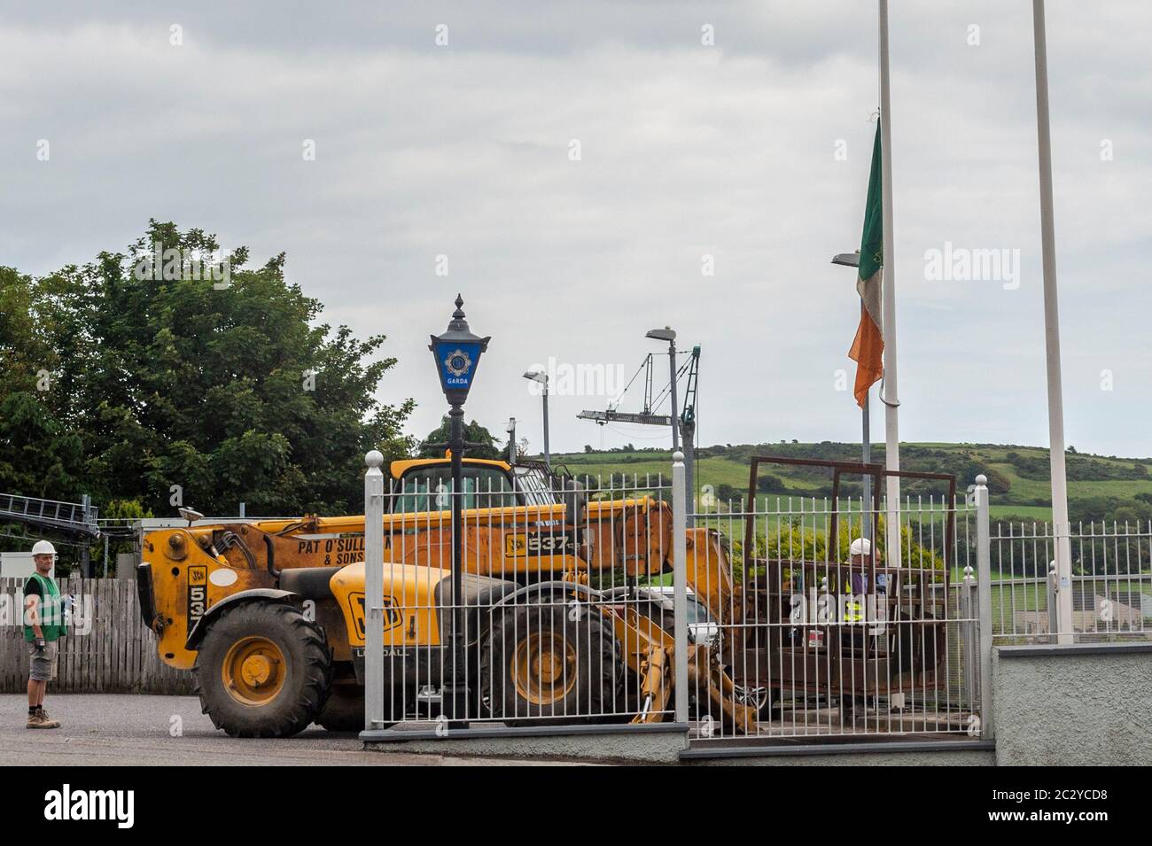 Clonakilty, West Cork, Ireland. 18th June, 2020. The Irish tricolour at Clonakilty Garda Station was flown at half mast today as a mark of respect to Detective Garda Colm Horkan who was murdered in Castlerea, Co. Roscommon last night. Garda Horkan was shot by his own weapon by a man in his 40's, who is now in custody. Workmen spent time this afternoon repairing the flagpole. Credit: AG News/Alamy Live News Stock Photo