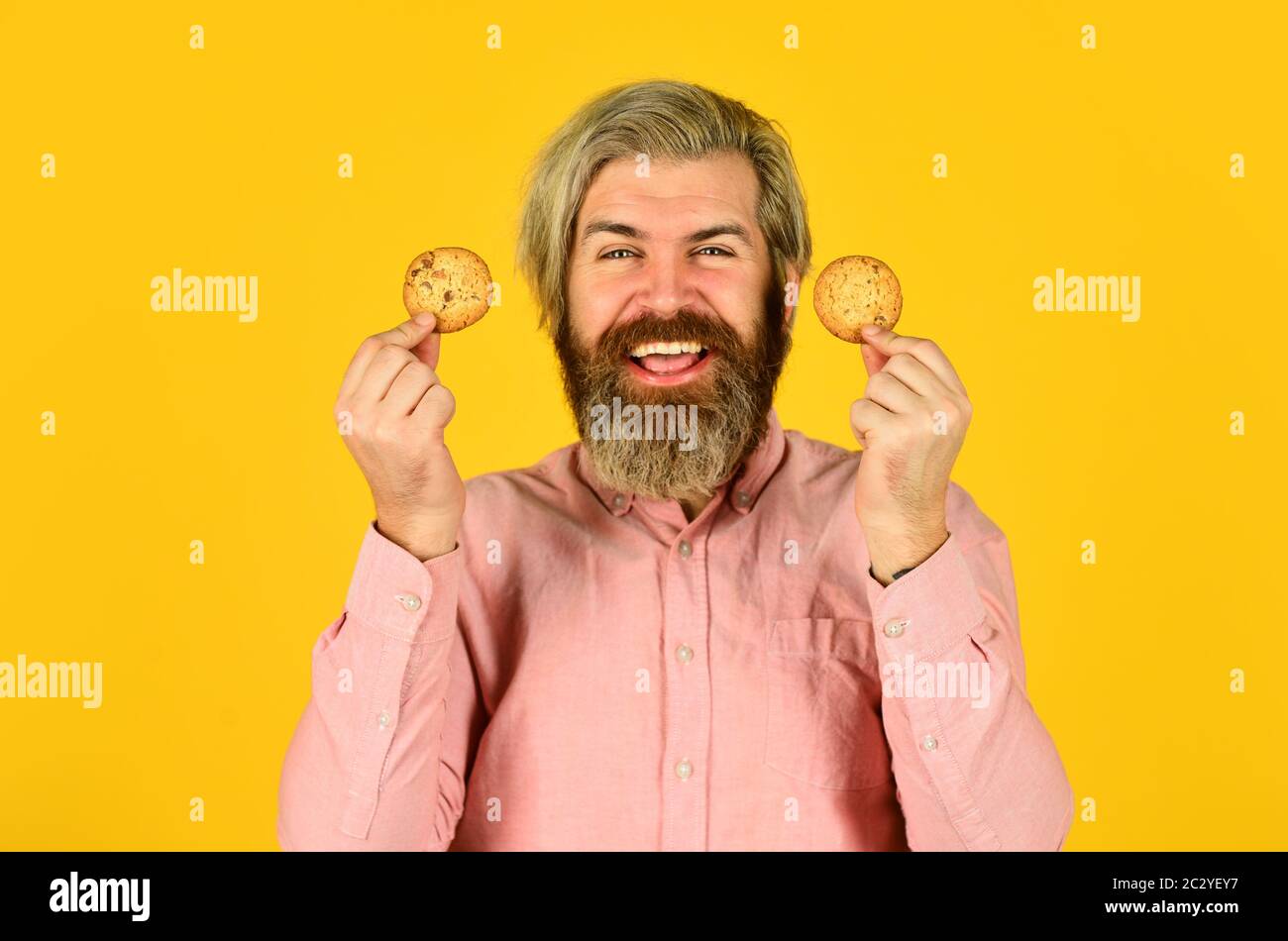 Excited man holding cookies. bearded hipster hold biscuit. full of