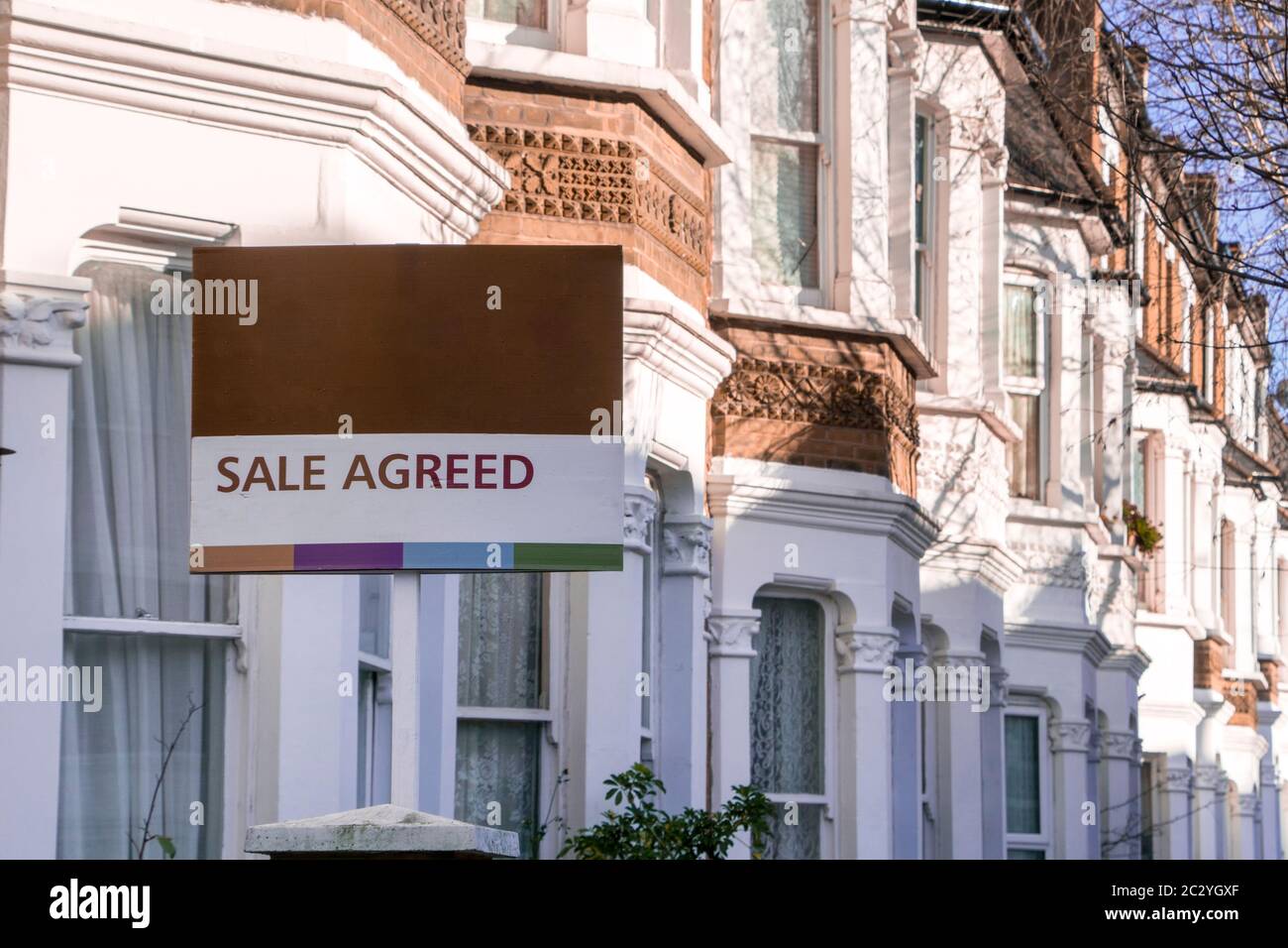 A row of typical British houses with 'sale agreed' estate agent sign Stock Photo Alamy