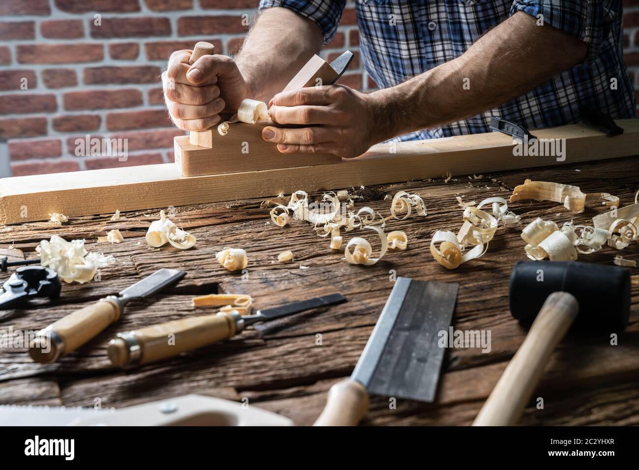 Carpenter Using Jackplane And Various Tools From Toolkit Stock Photo