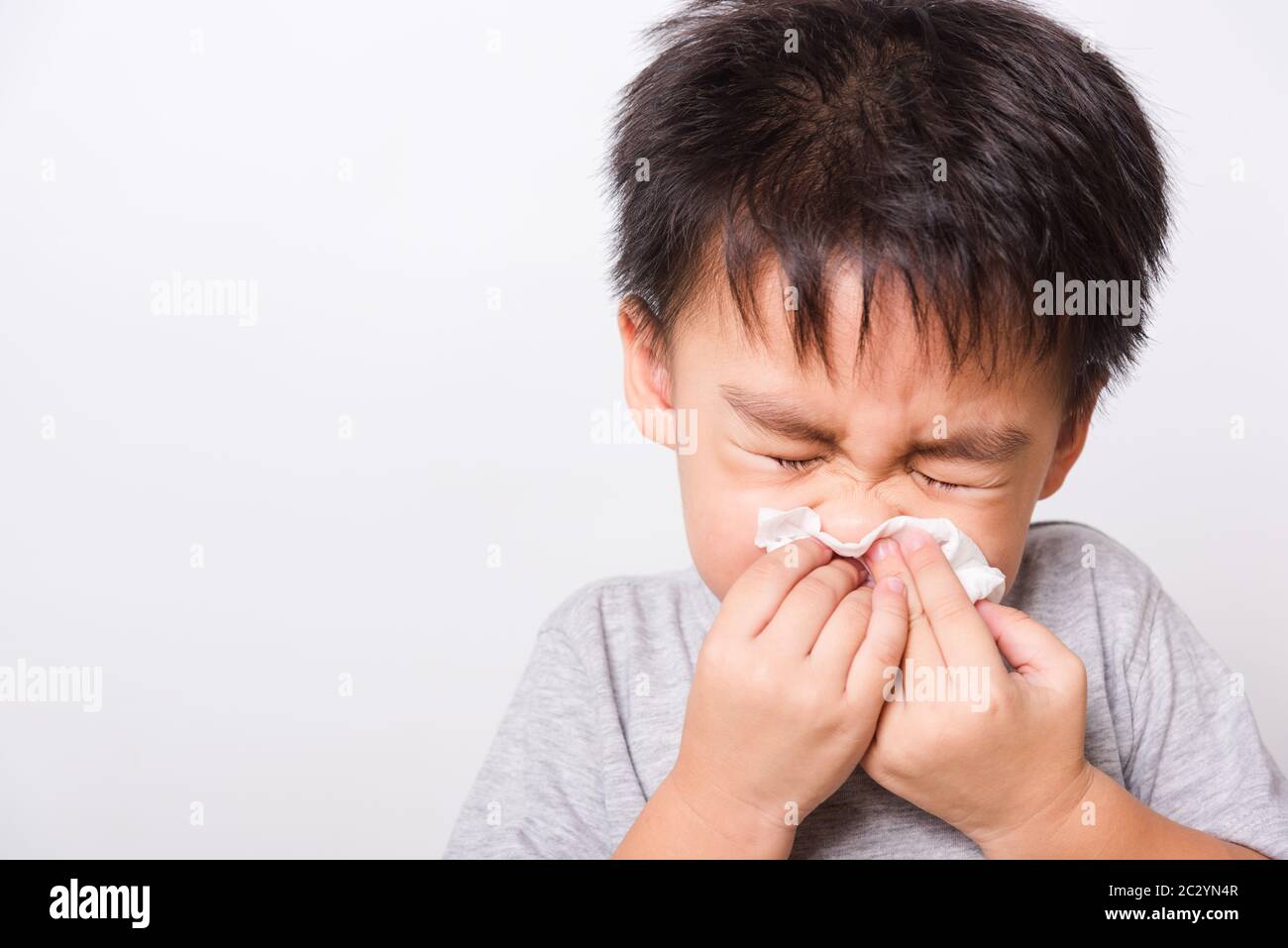 Closeup Asian face, Little children boy cleaning nose with tissue on