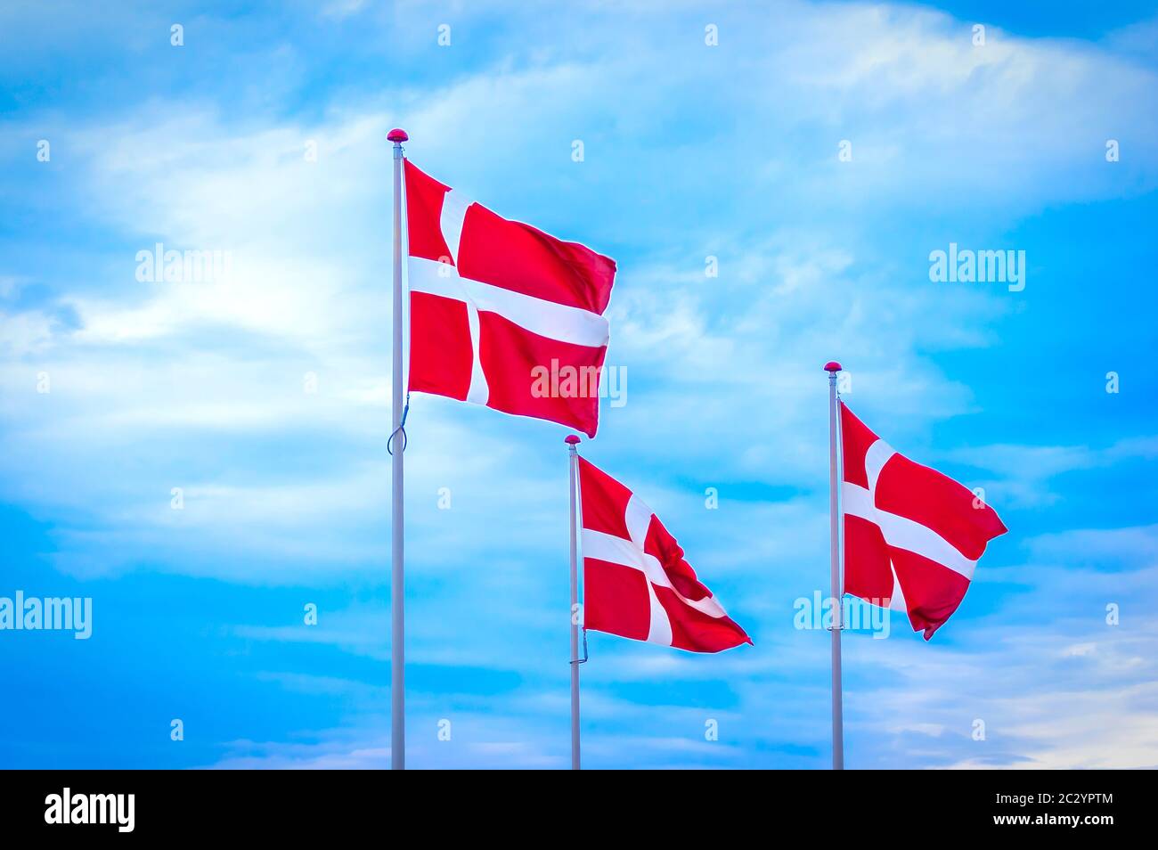 Denmark, Copenhagen: Three flags of the Kingdom of Denmark waving in the wind. Stock Photo