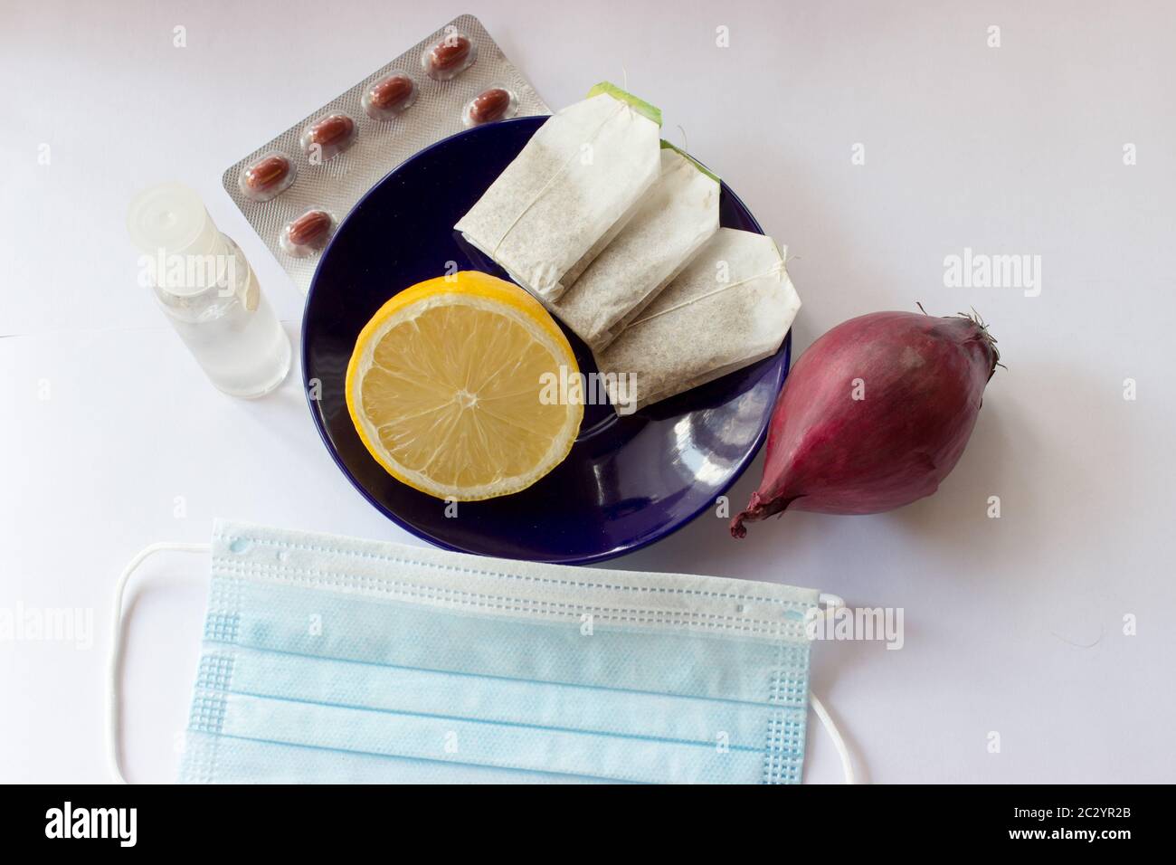 Flatly view of still life with drape, lemon, onion, tea, antibacterial disinfectant, pills - stop coronavirus Stock Photo
