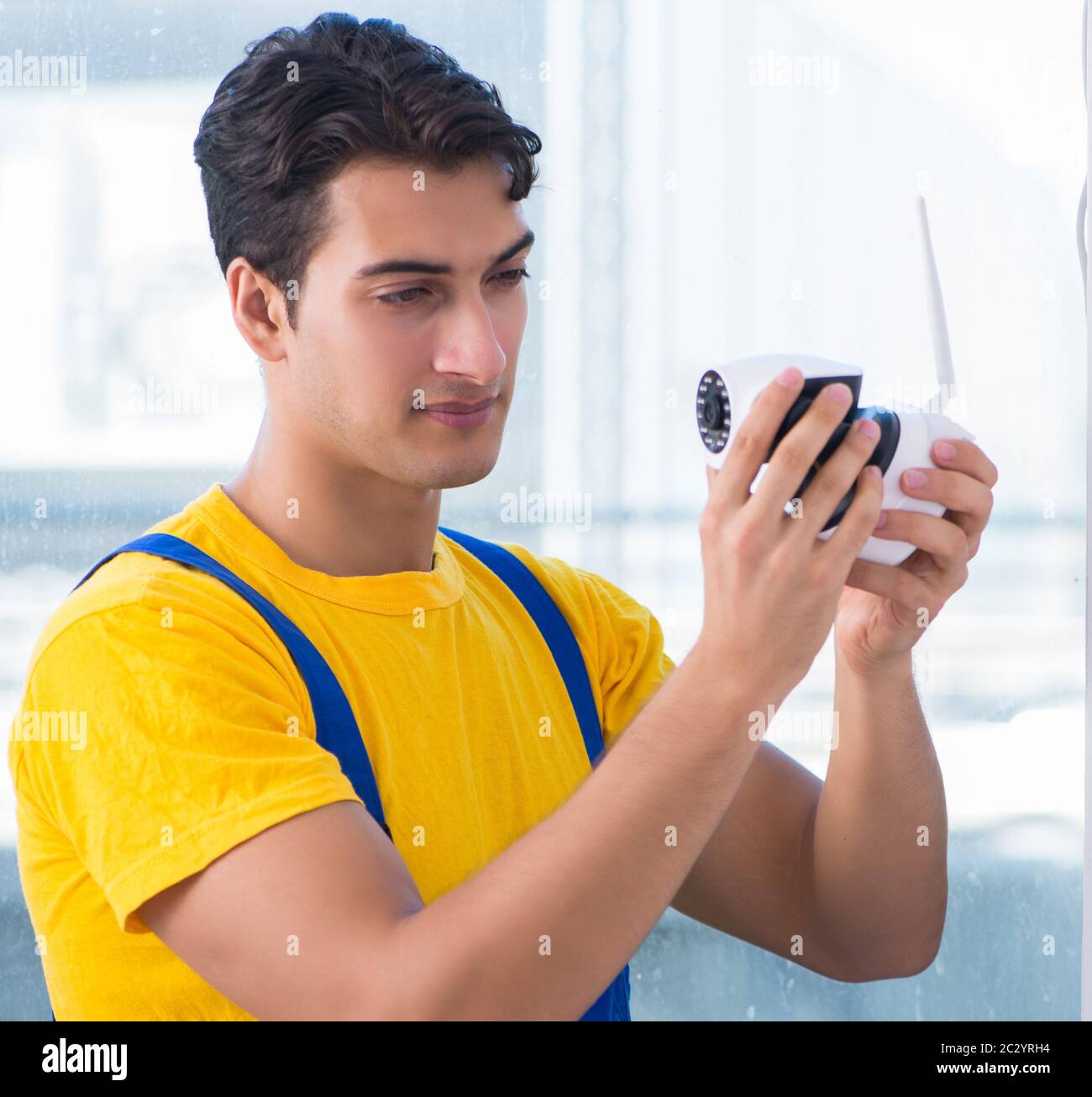 Contractor installing surveillance CCTV cameras in office Stock Photo