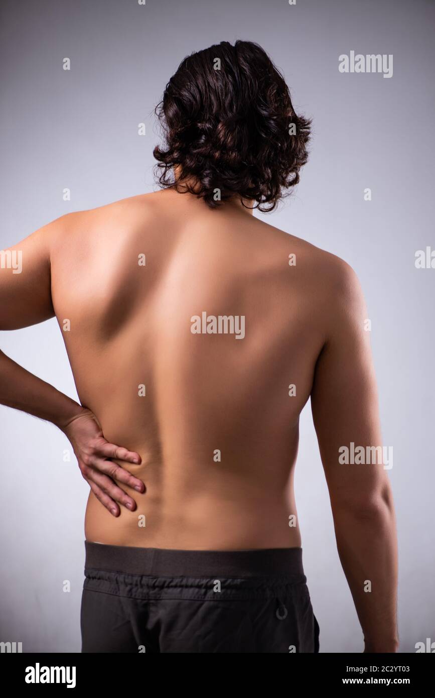 Man suffering from backbain on gray Stock Photo